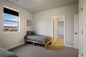 Bedroom featuring light carpet and baseboards