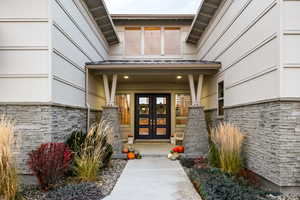 Entrance to property featuring stone siding and french doors