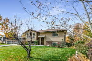 Raised ranch featuring brick siding and stucco siding