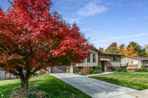 View of front of property featuring stucco siding, brick siding, a garage, and concrete driveway