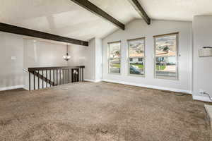 Spare room with carpet, a textured ceiling, and a chandelier