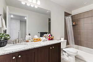 Bathroom featuring vanity, shower / tub combo, and light tile patterned floors