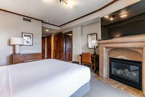 Bedroom 2with carpet, crown molding, and a glass covered fireplace