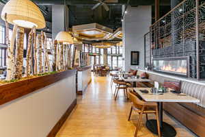 Hall featuring light wood finished floors and a towering ceiling