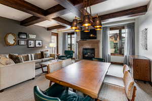 Dining area featuring beamed ceiling, a glass covered fireplace, and plenty of natural light