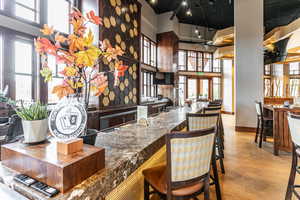 Community bar area with a high ceiling, healthy amount of natural light, and dark stone counters