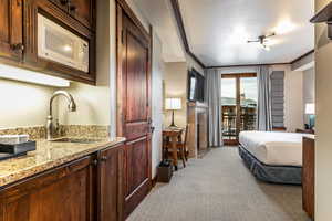 Bedroom 2with light colored carpet, access to exterior, a textured ceiling, and crown molding