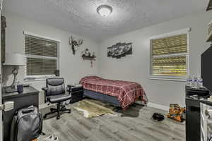 Bedroom featuring light wood-style flooring and a textured ceiling