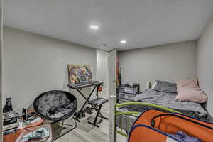 Bedroom with wood finished floors and recessed lighting