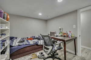 Home office with light wood-type flooring and recessed lighting