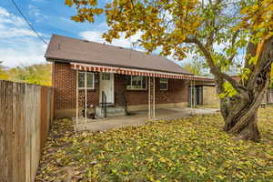 Back of property featuring a patio, a fenced backyard, roof with shingles, brick siding, and entry steps