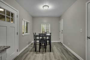 Dining room with a textured ceiling and light wood-type flooring