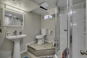 Bathroom featuring a shower stall and wood finished floors