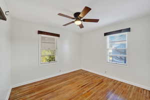 Empty room featuring hardwood / wood-style floors and ceiling fan
