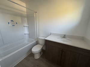 Full bath featuring vanity, dark wood-type flooring, and tub / shower combination