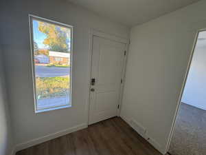 Entryway with baseboards and wood finished floors