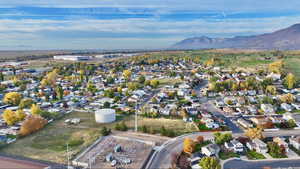 Aerial overview of property's location with nearby suburban area and a mountainous background