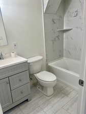 Full bathroom with vanity, bathing tub / shower combination, and light marble finish floors