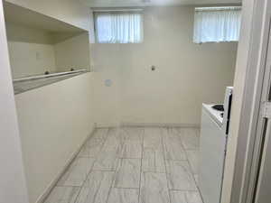 Laundry area with baseboards and light marble finish flooring