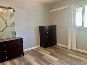 Bedroom featuring wood finished floors and baseboards