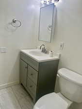 Half bathroom featuring vanity and toilet