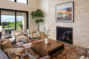 Example of living room with a stone fireplace, wood finished floors, and a mountain view
