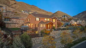 View of front of property featuring stucco siding, a patio area, a mountain view, and stone siding
