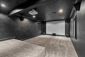 Cinema room featuring light colored carpet, crown molding, recessed lighting, and a textured ceiling