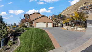 View of front facade featuring stucco siding, driveway, and an attached garage
