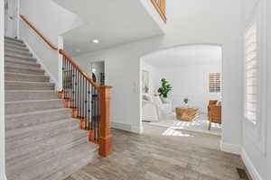 Entryway featuring arched walkways, wood finished floors, and stairway