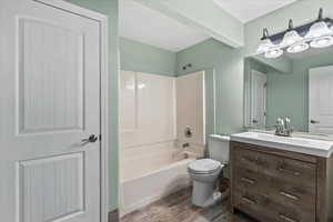 Bathroom with vanity, wood finished floors, and bathtub / shower combination