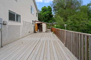 Wooden terrace featuring view of wooded area
