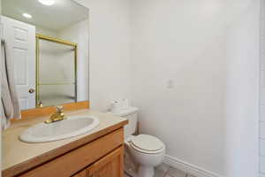 Bathroom featuring vanity, light tile patterned floors, and a shower stall
