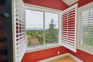 Unfurnished sunroom featuring view of wooded area and a mountain view