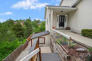 Property entrance featuring stucco siding and a shingled roof