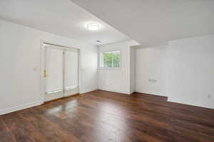 Spare room featuring a textured ceiling and dark wood-type flooring