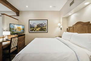 Bedroom with recessed lighting, an office area, and beam ceiling