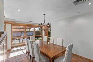 Formal dining room off the kitchen with a chandelier and recessed lighting