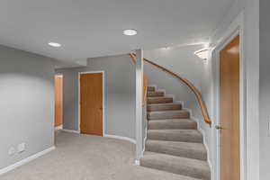 Downstairs landing area. Door on left is where a water heater and water softener are. The hall on the left goes to a bedroom and full bathroom.