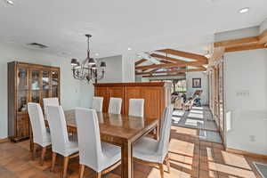 Formal dining room off the kitchen with a chandelier and recessed lighting