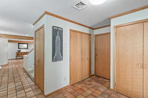 Hallway looking back to entryway. On the right is extra storage and door to garage.
