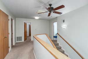 Upstairs landing looking at bedroom 1 on right, full bathroom in middle, and bedroom 2 on left. There are storage closets on the immediate left hand side.