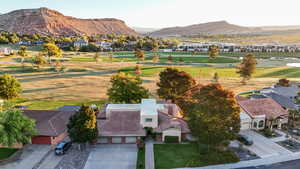 Aerial perspective of suburban area featuring a golf course and a mountainous background