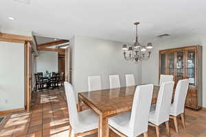 Formal dining room off the kitchen with a chandelier and recessed lighting