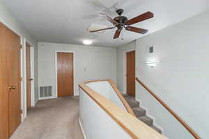 Upstairs landing looking at bedroom 1 on right, full bathroom in middle, and bedroom 2 on left. There are storage closets on the immediate left hand side.