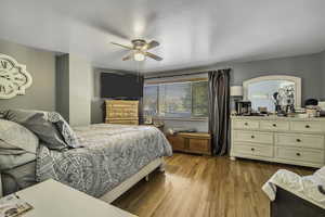 Bedroom with light wood-type flooring and a ceiling fan