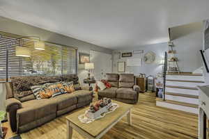 Living room with wood finished floors and stairway