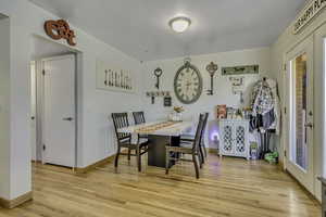 Dining space with light wood-style flooring and baseboards