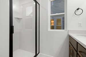 Bathroom featuring a stall shower and vanity