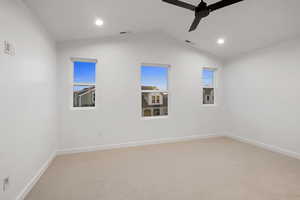 Carpeted spare room with vaulted ceiling, a ceiling fan, and recessed lighting